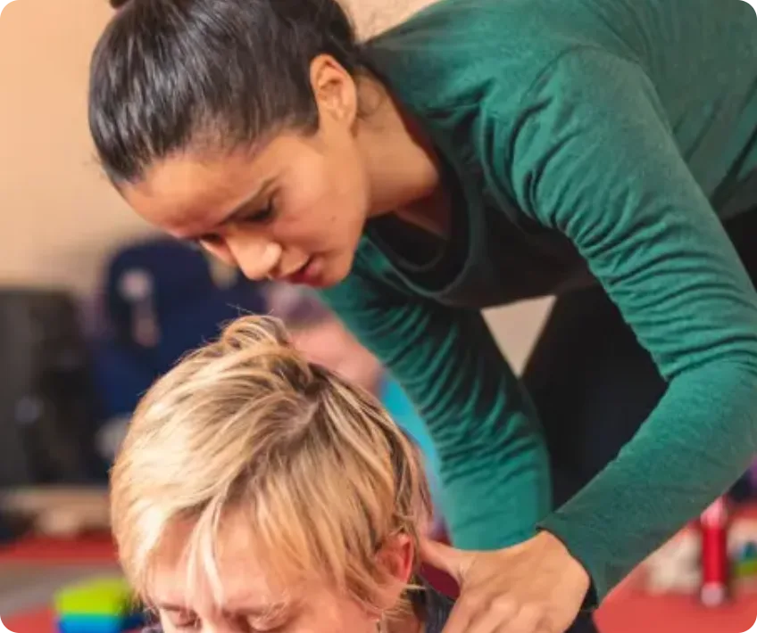 Priyanka Karki assisting a student with hands-on alignment during Ashtanga Vinyasa yoga practice at Rishikesh Yog Nirvana