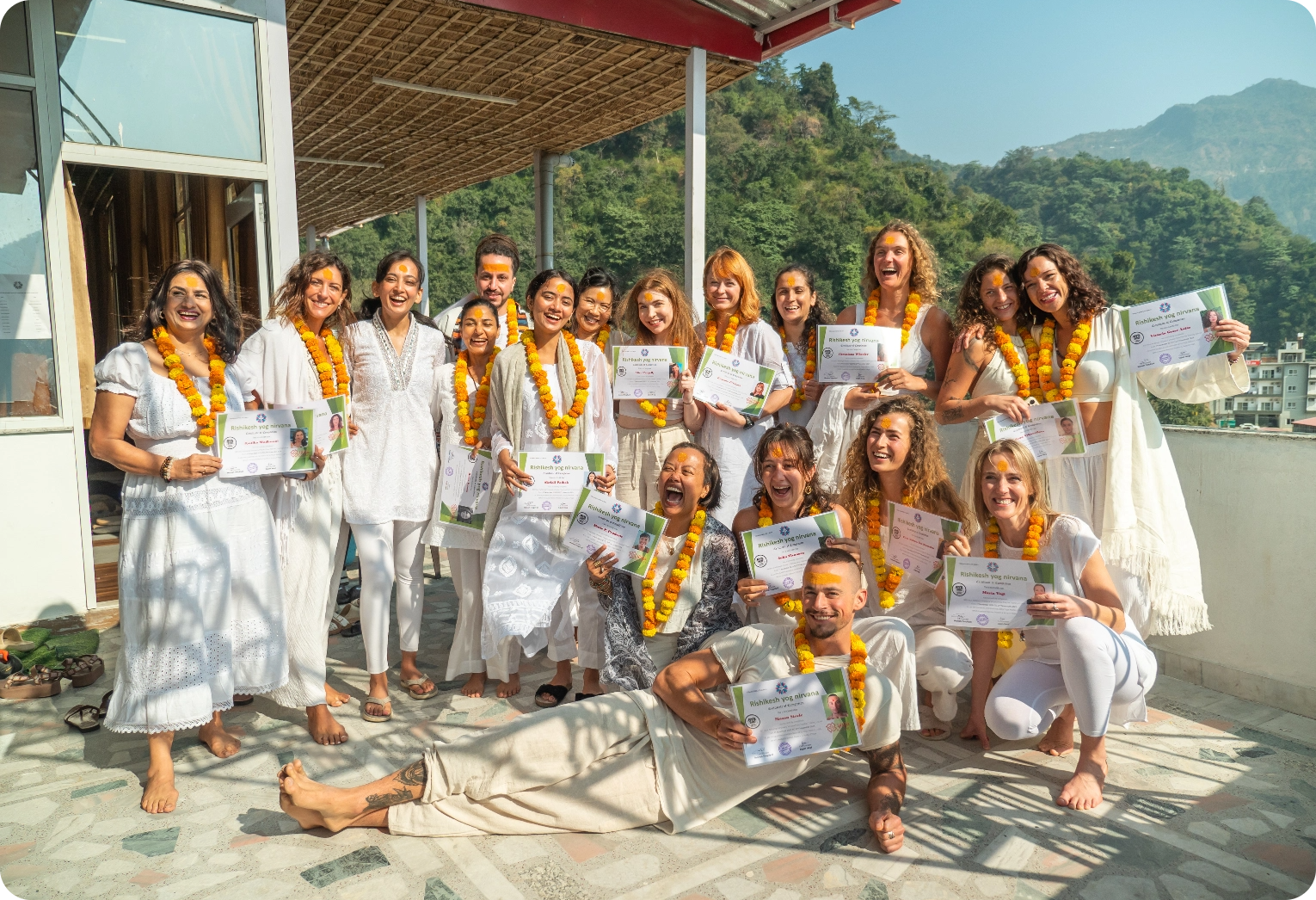 International yoga teacher training students celebrating graduation with certificates at Rishikesh Yog Nirvana in Rishikesh