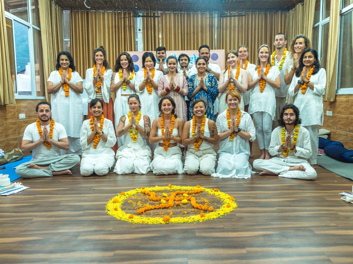 Rishikesh Yog Nirvana students posing together in the yoga hall.