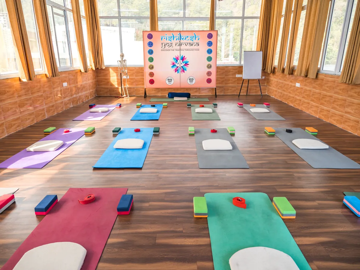 The Rishikesh Yog Nirvana yoga hall set up with mats, blocks and cushions for a class