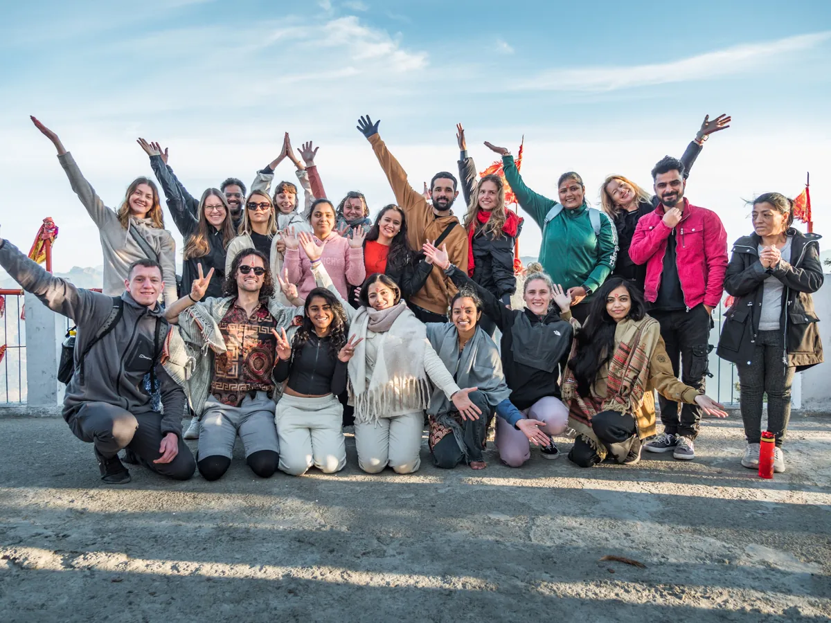 A graduating batch of Rishikesh Yog Nirvana students cheering together on the school rooftop