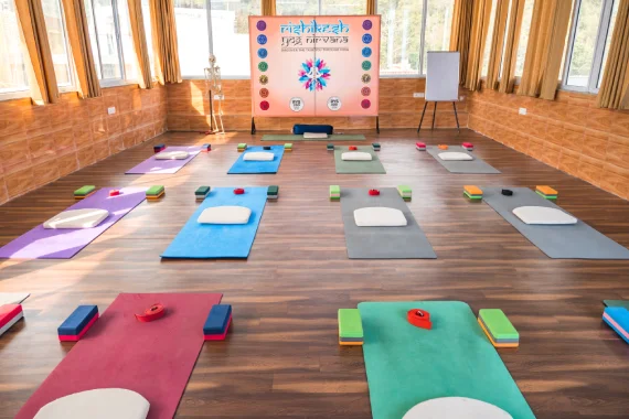 Simple and functional accommodation space at a yoga ashram in Rishikesh with calm interiors supporting yoga teacher training